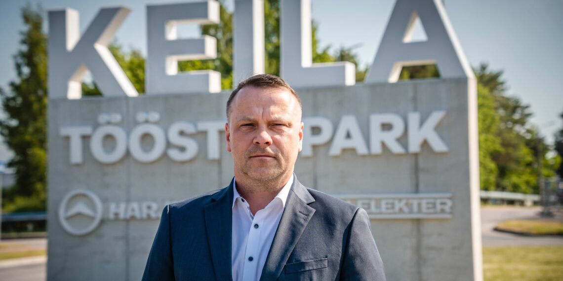 Harju KEKi tegevjuht Janek Lehtmets seismas Eesti vanima ja kaasaegseima tööstuslinnaku Keila Tööstuspargi väravas.