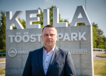 Harju KEKi tegevjuht Janek Lehtmets seismas Eesti vanima ja kaasaegseima tööstuslinnaku Keila Tööstuspargi väravas.